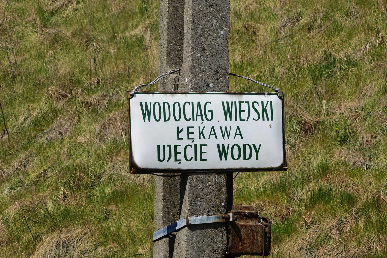 tabliczka na&nbsp;słupie z&nbsp;napisem wodociąg wiejski łękawa ujęcie wody