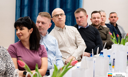 mężczyźni i kobiety siedzą przy stole w sali świetlicy w Emilinie