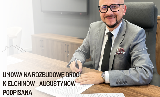 wójt gminy bełchatów konrad koc siedzi przy biurku i pdpisuje umowę