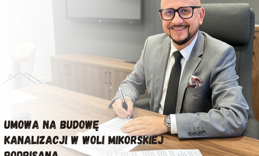 wójt konrad koc podpisuje umowę siedząc przy biurku