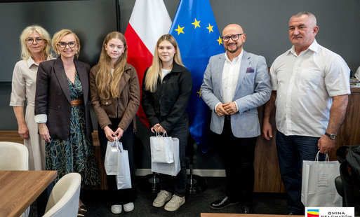 dwie dziewczynki stoja  torebkami prezentowymi, obok nich wójt konrad koc, radna bogusława maziarz, dyrektor CSIP Beata Wilińska i trener Tomasz Stróż