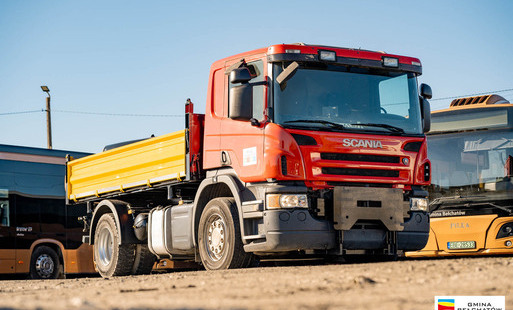 samochód ciężarowy marki scania, w tle stojące autobusy