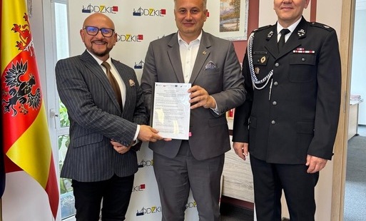 wójt konrad koc i wicemarszałek województwa łódzkiego stoją w towarzystwie strażaka z osp zawadów