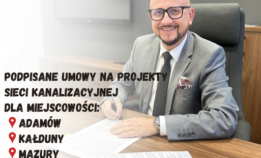 wójt konrad koc podpisuje umowę siedząc przy biurku